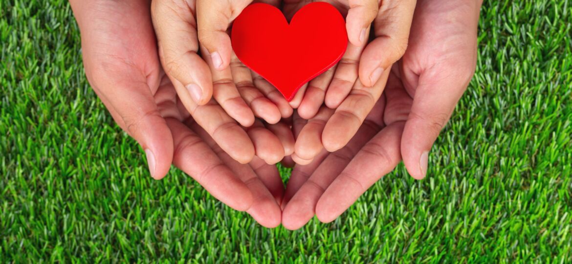 red heart shape in family member's hands holding